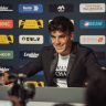 Óscar Casas en una escena de la serie de HBO Pollos sin cabeza. Aparece en una sala de prensa de un estadio de fútbol con publicidad al fondo.